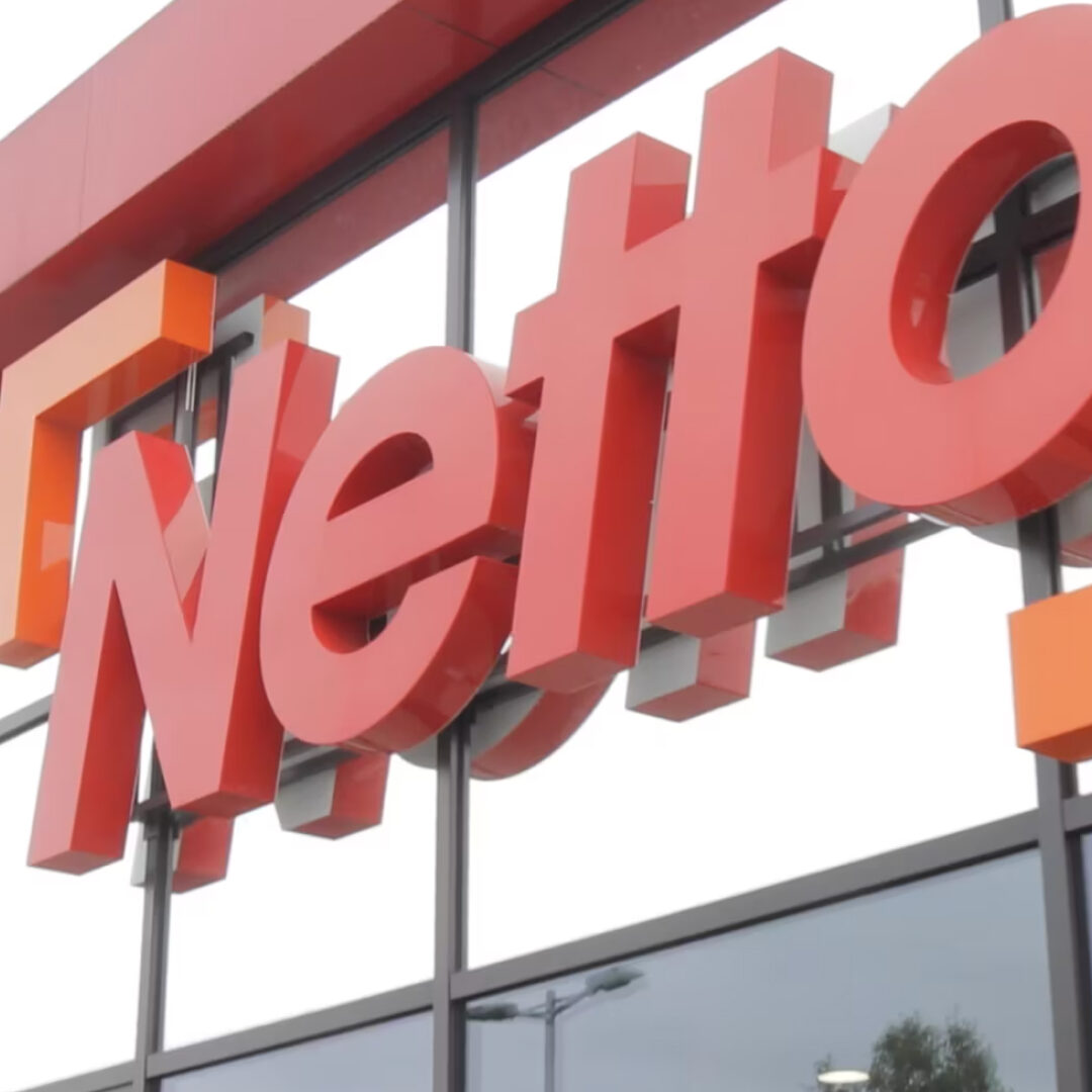 L'image montre le logo rouge de la chaîne de supermarchés Netto sur un bâtiment.