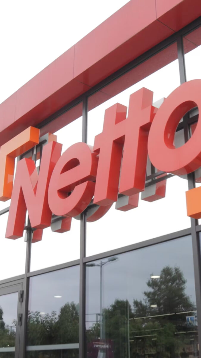 L'image montre le logo rouge de la chaîne de supermarchés Netto sur un bâtiment.